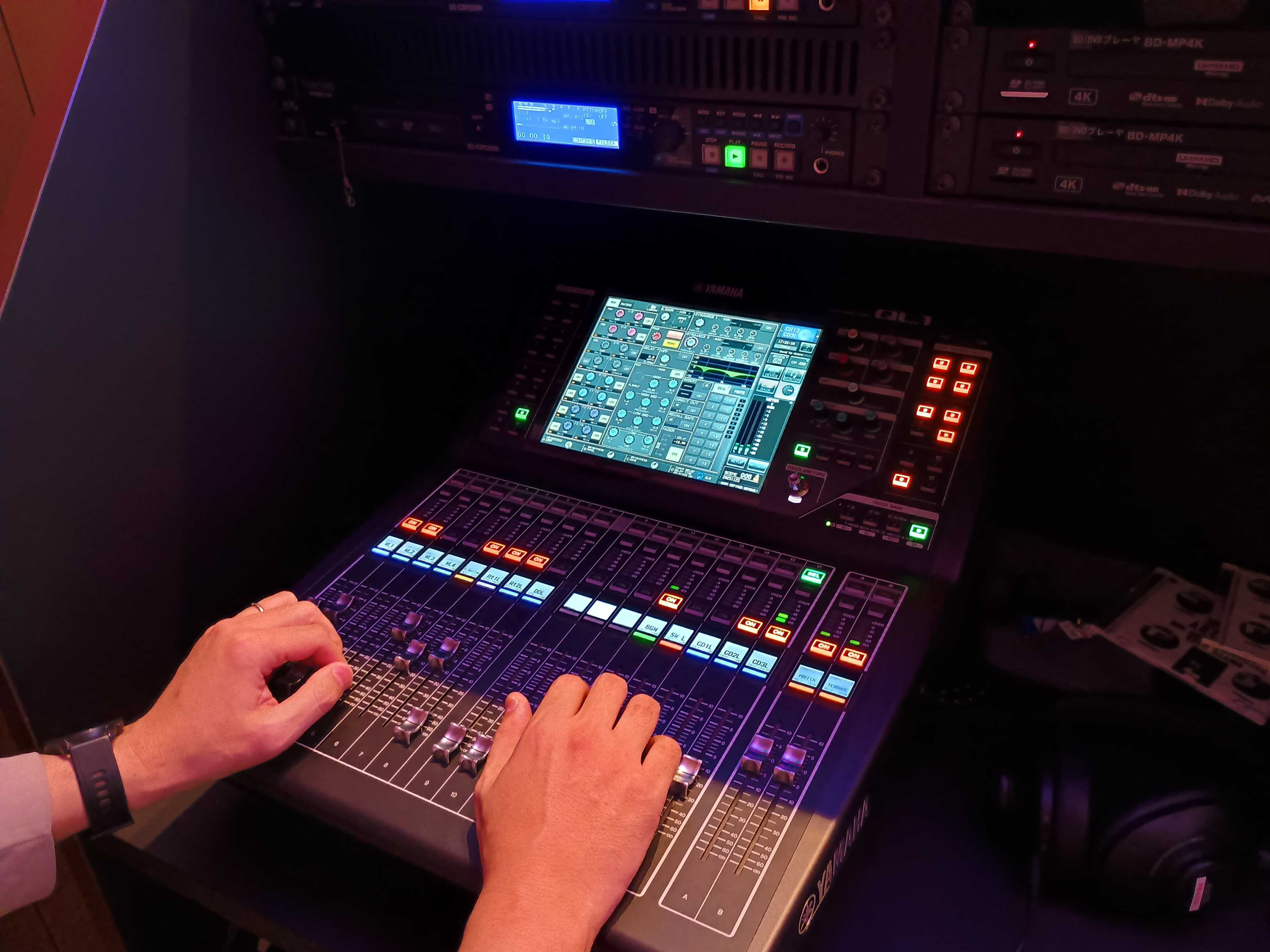 音響機器を操作する手元